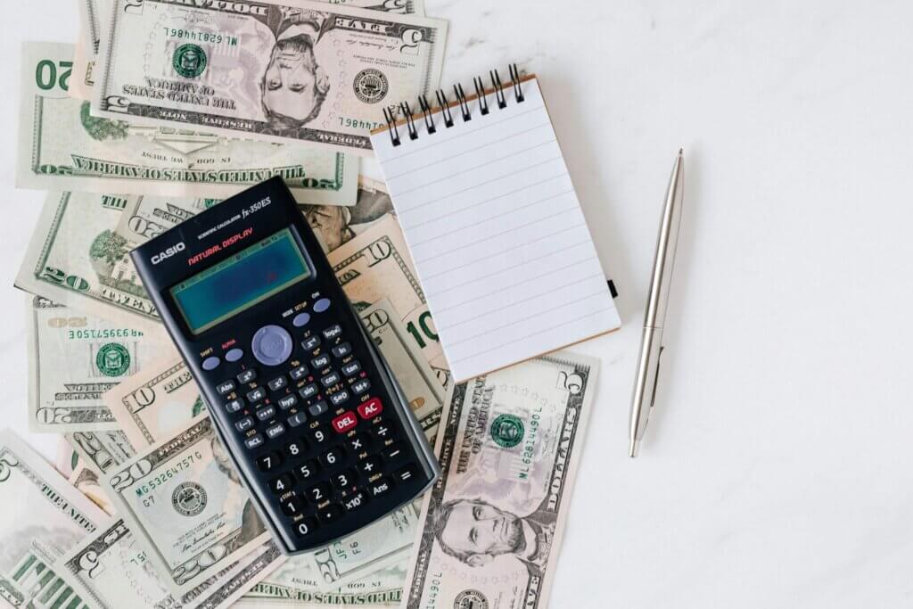 money calculator and notebook on white table